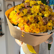 Beautiful bouquet of yellow roses in kraft paper.