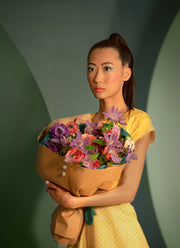 Pink and purple bouquet in the arms of a girl