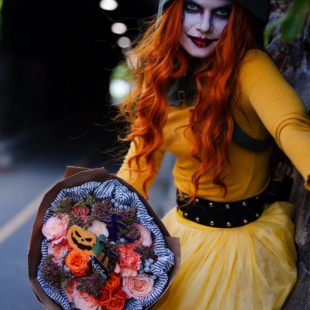 Scary halloween character with orange bouquet