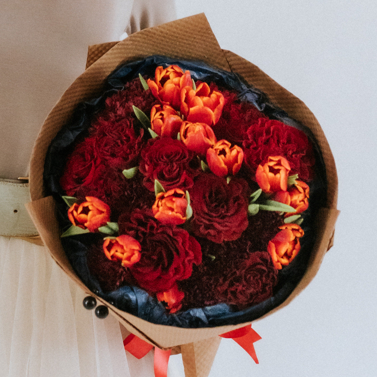 Bouquet of red roses, burgundy carnations, and red tulips