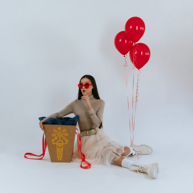 Gift box for a bouquet near the girl with balloons
