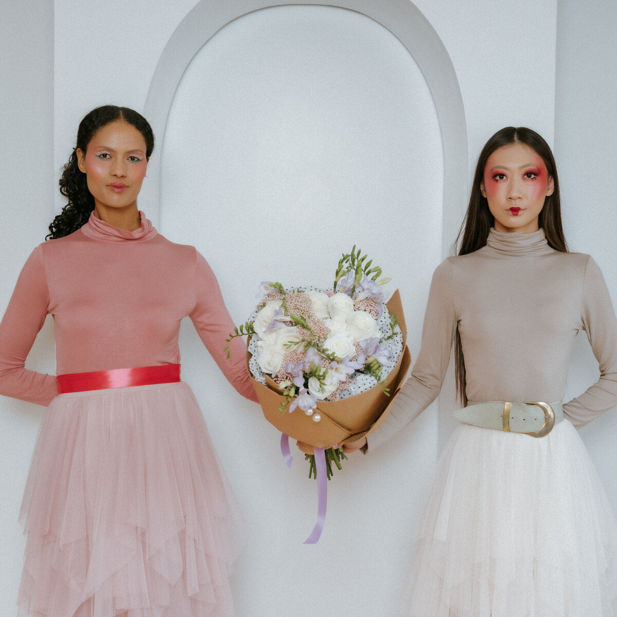 Bouquet of white roses in the hands of two girls