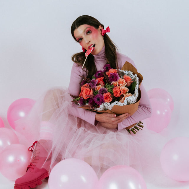 Bright flower bouquet on the arms of the girl in pink
