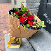 Red and green bouquet wrapped in Kraft paper