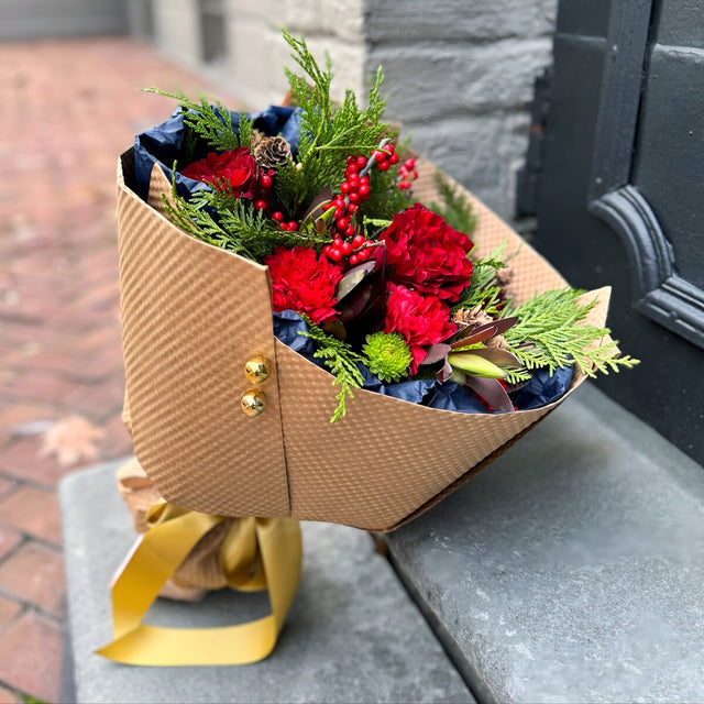 Red and green bouquet wrapped in Kraft paper