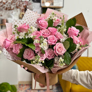 Romantic bouquet with fresh pink roses and white stock flowers.