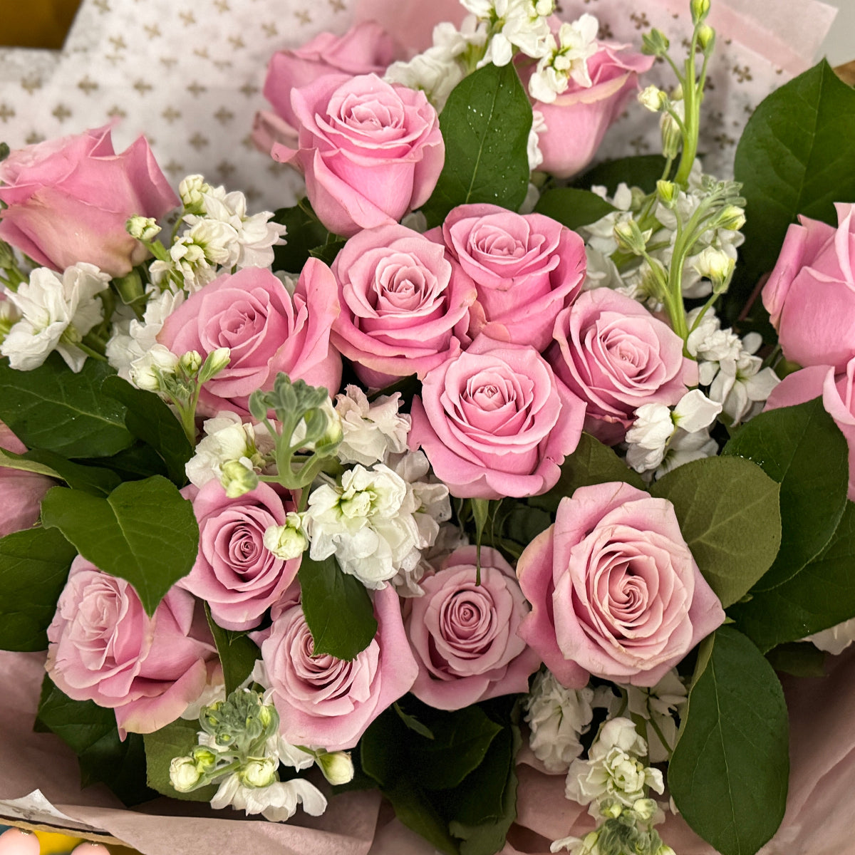 Pink roses and white stock flowers  in the bouquet.