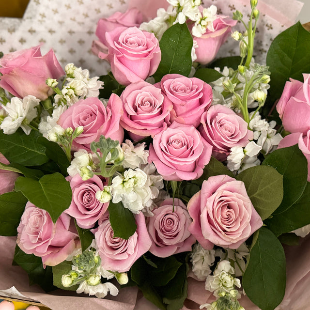 Pink roses and white stock flowers  in the bouquet.