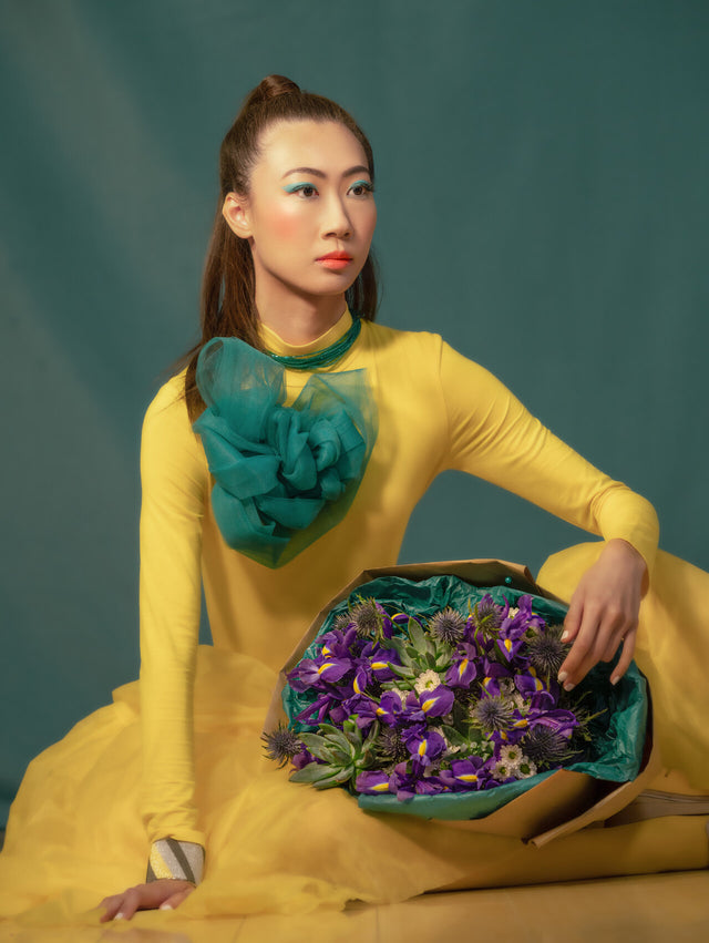 Elegant bouquet of blue irises, purple thistle, and a succulent, beautifully wrapped in eco-friendly kraft paper and green tissue. A harmonious mix of bold colors of the flowers and sustainable materials