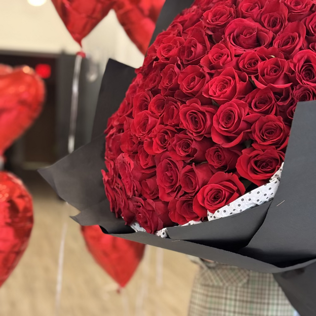 100 red roses bouquet wrapped in elegant black paper
