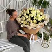 white hundred roses held by woman 