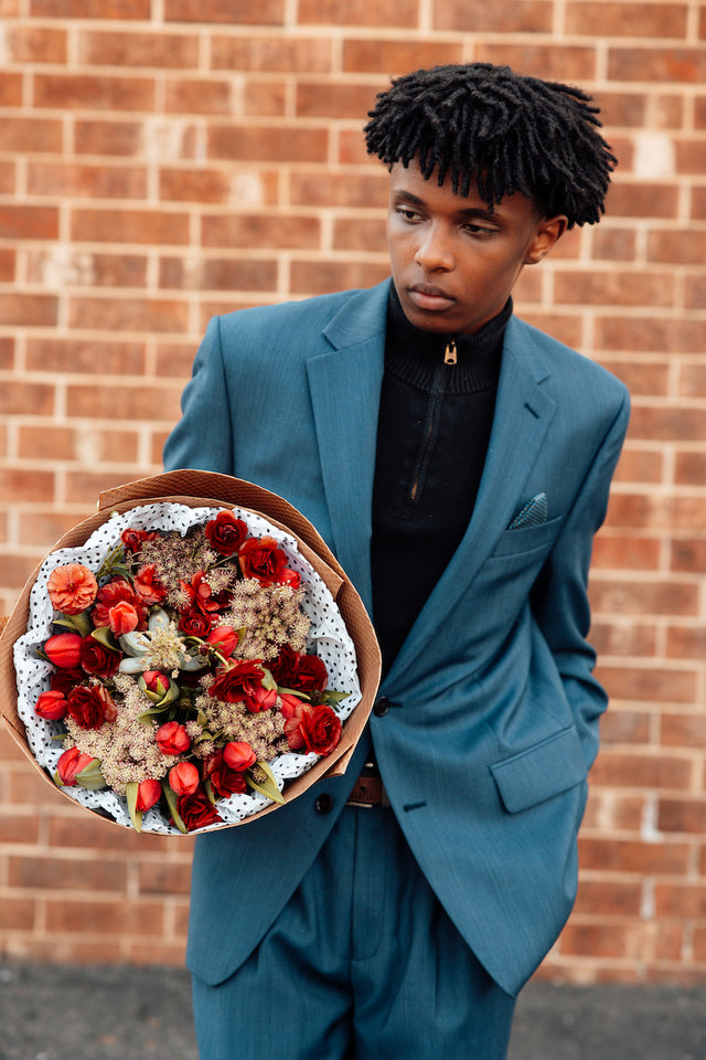 Bouquet of red flowers held by a man