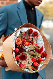 Bouquet of red flowers in the hands of a man