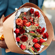 Bouquet of red flowers in the hands of a man