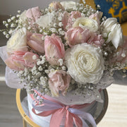 Soft pink flower bouquet with tulips, ranunculus, and baby's breath.