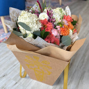 Fall flowers bouquet in a beautiful delivery cone box, featuring a mix of orange, pink, and cream white flowers.