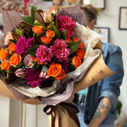 Bouquet of flowers held by a person in an indoor setting