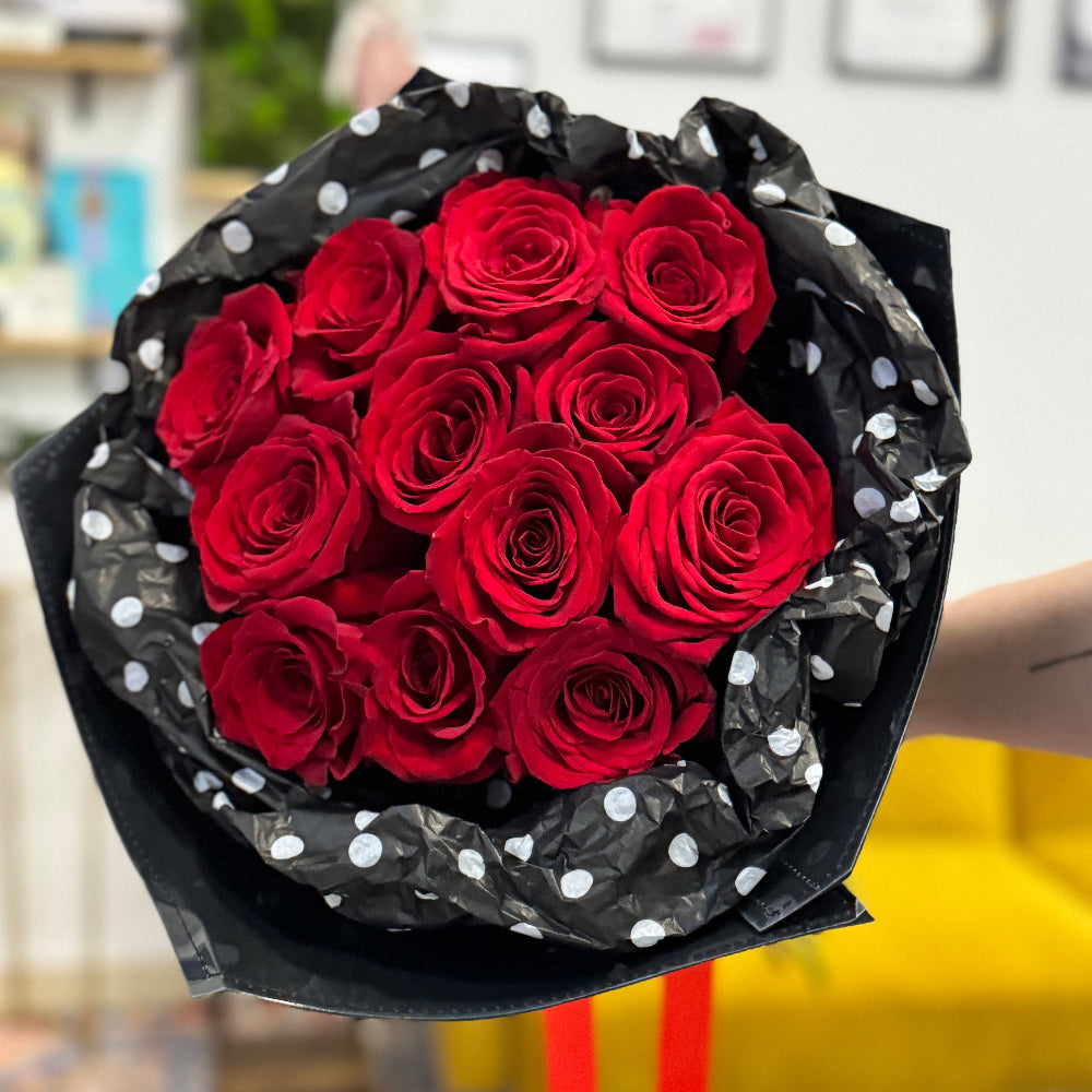 Classic red roses Valentine’s bouquet wrapped in polka dot tissue and kraft paper