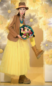 Bouquet of ranunculus in the arms of a girl in yellow