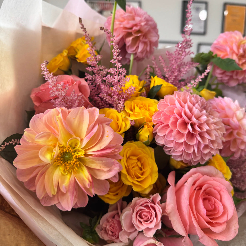 Freshly cut dahlias in a romantic garden-inspired floral arrangement.