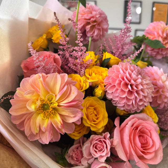Freshly cut dahlias in a romantic garden-inspired floral arrangement.