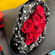 Dozen long-stem red roses wrapped in black and white polka dot paper