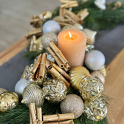 Elegant Christmas table centerpiece in S-shape featuring lush pine greenery and metallic ornaments