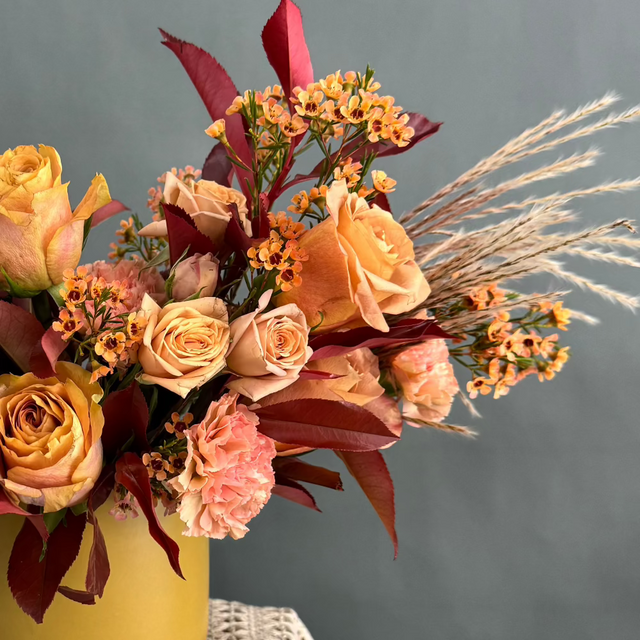 Close-up of autumn flowers, including roses, carnations in the vase.