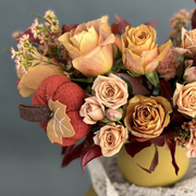 Close-up of a fall floral arrangement with roses, carnations, wax flowers.