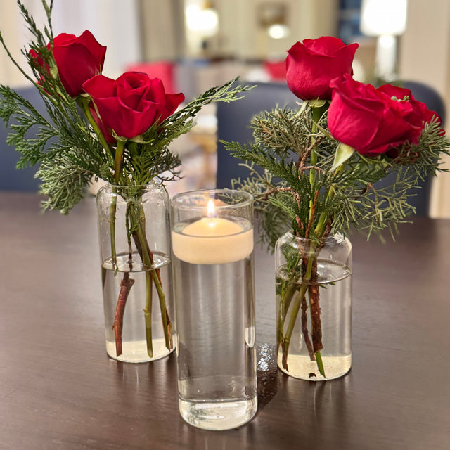 Modern holiday table arrangement with mixed evergreens and floral accents