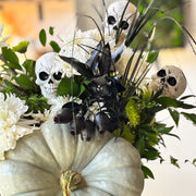 White chrysanthemums and green button mums with eucalyptus, ruscus, and miniature skulls