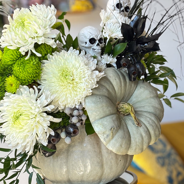 Halloween pumpkin flowers with white mums, green button mums, berries, and black decorative accents