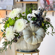 Halloween floral arrangement with white chrysanthemums, green button mums, eucalyptus, and skull accents