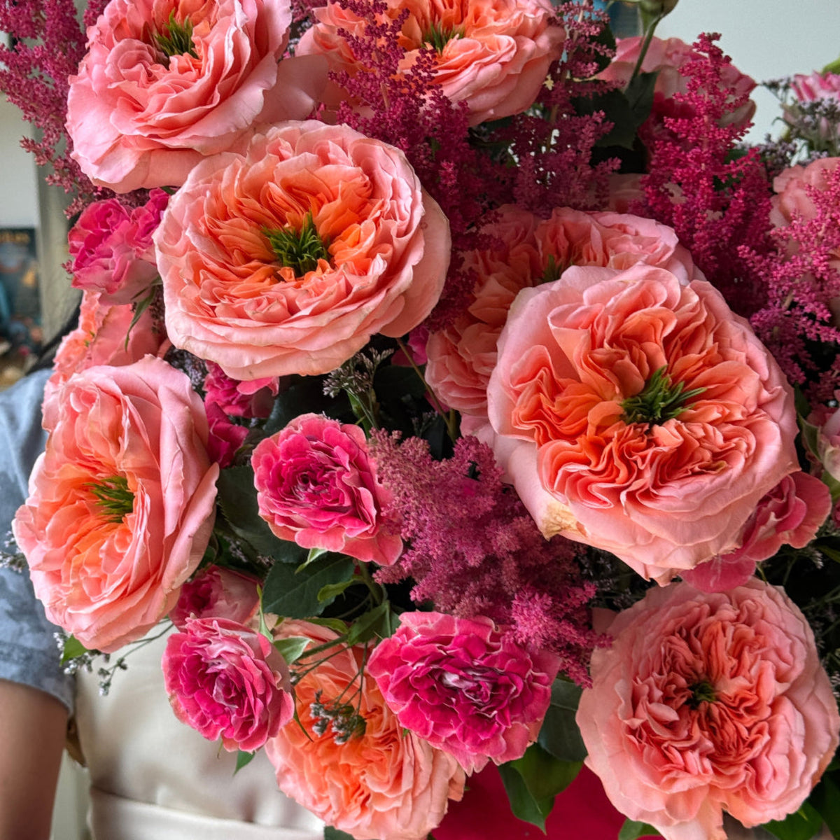 Luxury floral arrangement with garden roses, spray roses, astilbe, hanging amaranthus, and seasonal accent flowers.