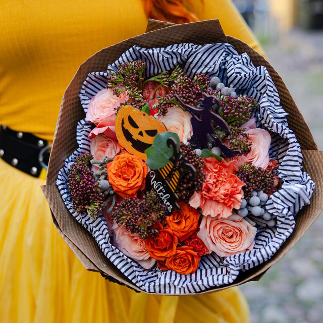 Close up of orange Halloween bouquet with scary pumpkin details. 