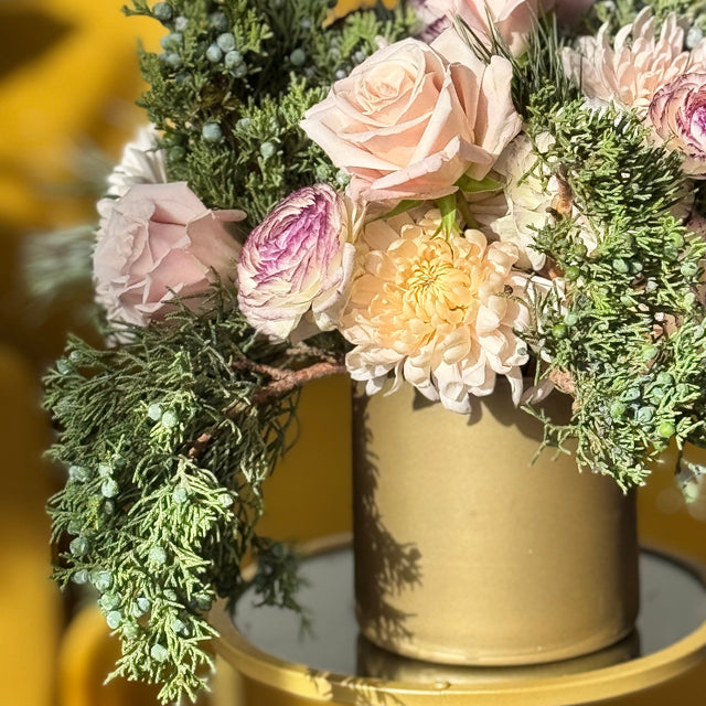 Holiday floral centerpiece in soft pink tones with evergreen juniper arrangement in Springfield VA
