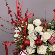 Holiday fresh flowers basket with ornaments and red details. 