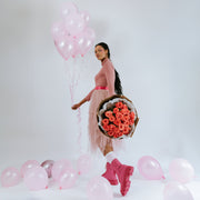 Coral rose bouquet in the hands of a girl with balloons
