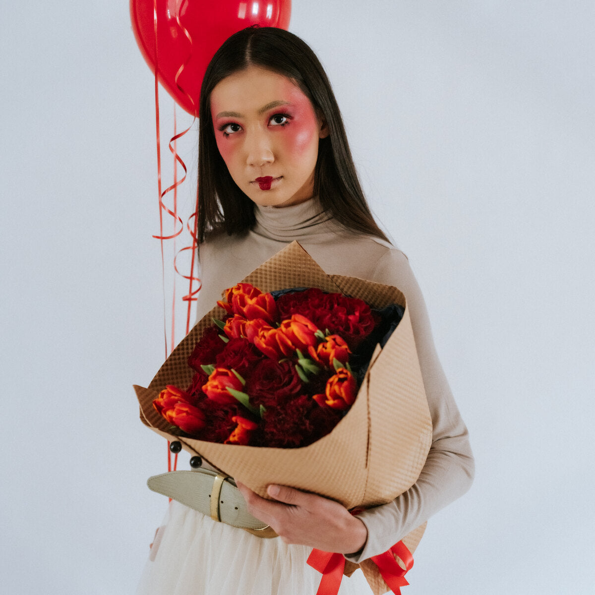 Bouquet of roses, carnations, and tulips in the arms of a girl