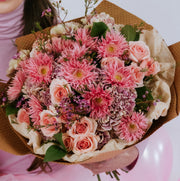 Bouquet of pink flowers wrapped in Kraft paper