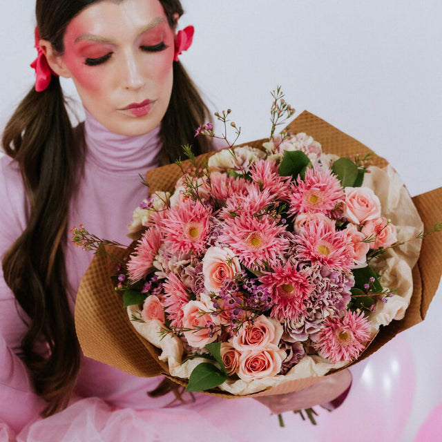 Pink flower bouquet in the arms of a girl