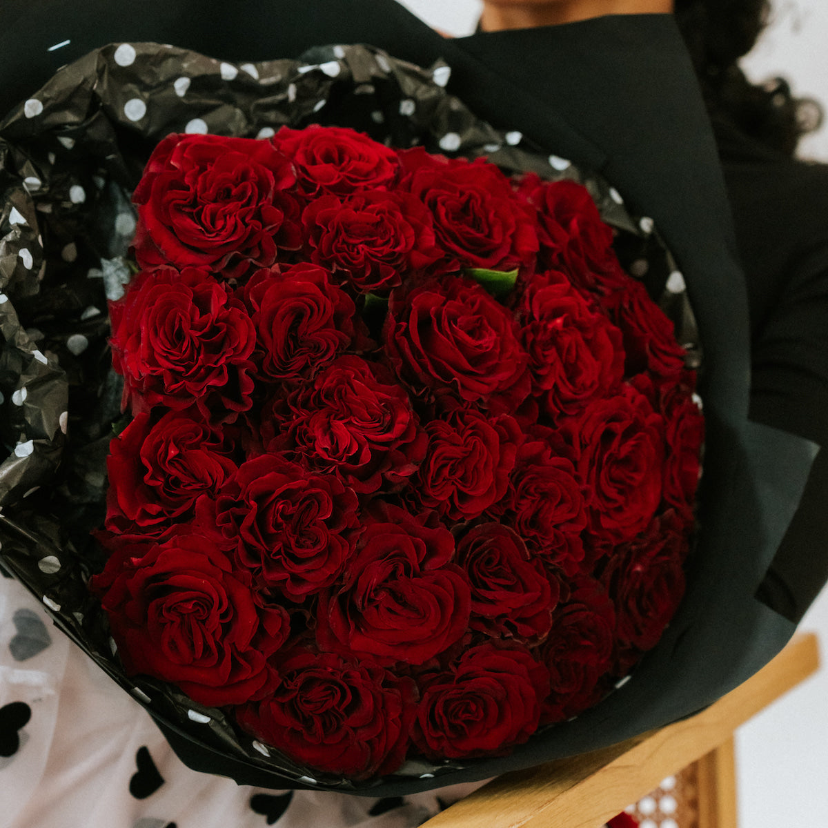 Red bouquet of roses in black wrapping paper