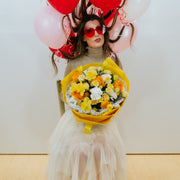 Yellow and white bouquet in the arms of a girl with heart glasses