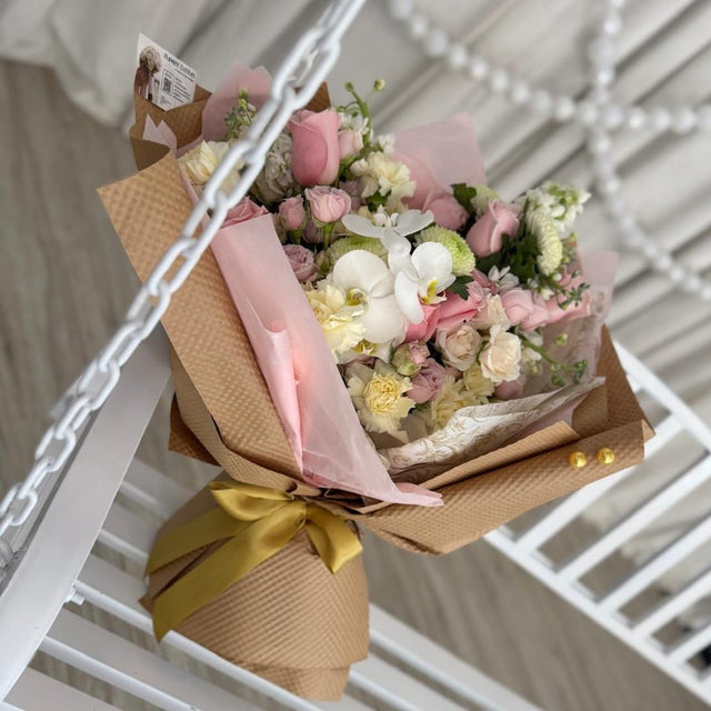 Hand-tied luxury bouquet with pastel pink spray roses and orchids.