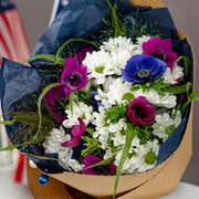 Close-up of Liberty Garden Bouquet showing asters, anemones, and natural grass