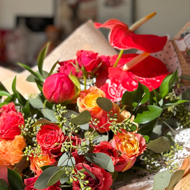 Bouquet of flowers with pink and orange tones in a blurred indoor setting