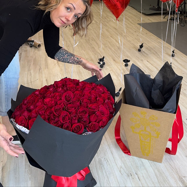 Luxury Valentine’s Day bouquet of one hundred red roses in black wrap