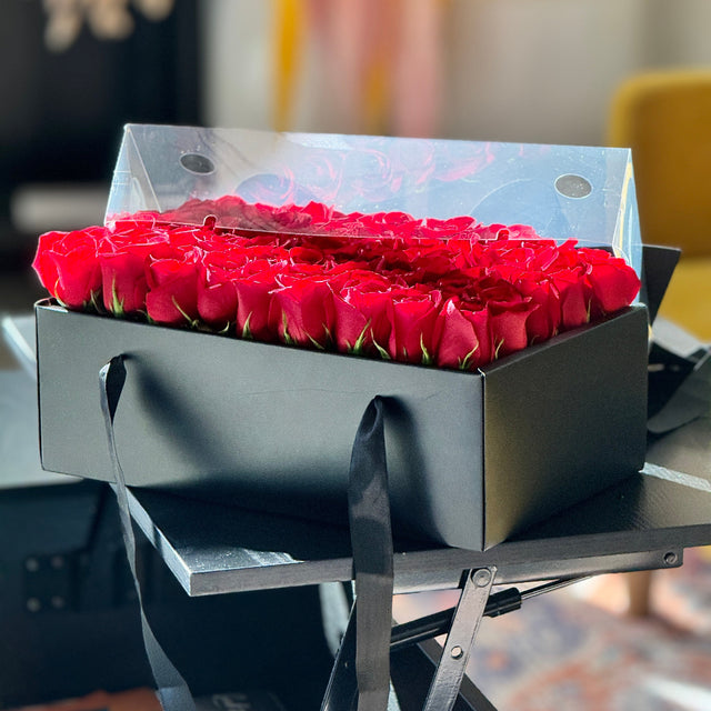 Luxury red rose arrangement in a black box with clear lid