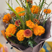 Top view of Marigold Bouquet with rich fall textures and warm yellow-orange hues.