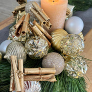 Modern 30-inch pine holiday centerpiece decorated with gold and silver ornaments and gold-painted cinnamon sticks